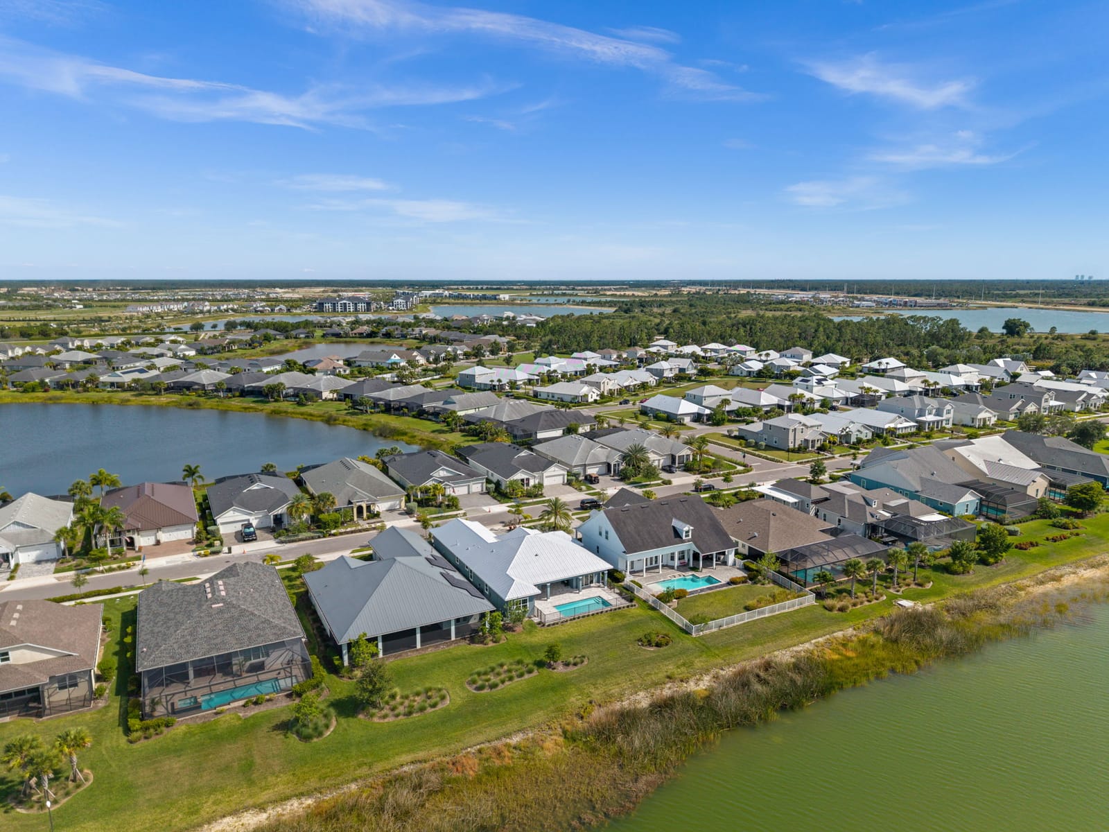 Aerial view of a lakefront neighborhood of homes with pools in Babcock Ranch, Florida